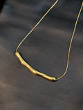 A statement arc necklace or bamboo-textured slice necklace