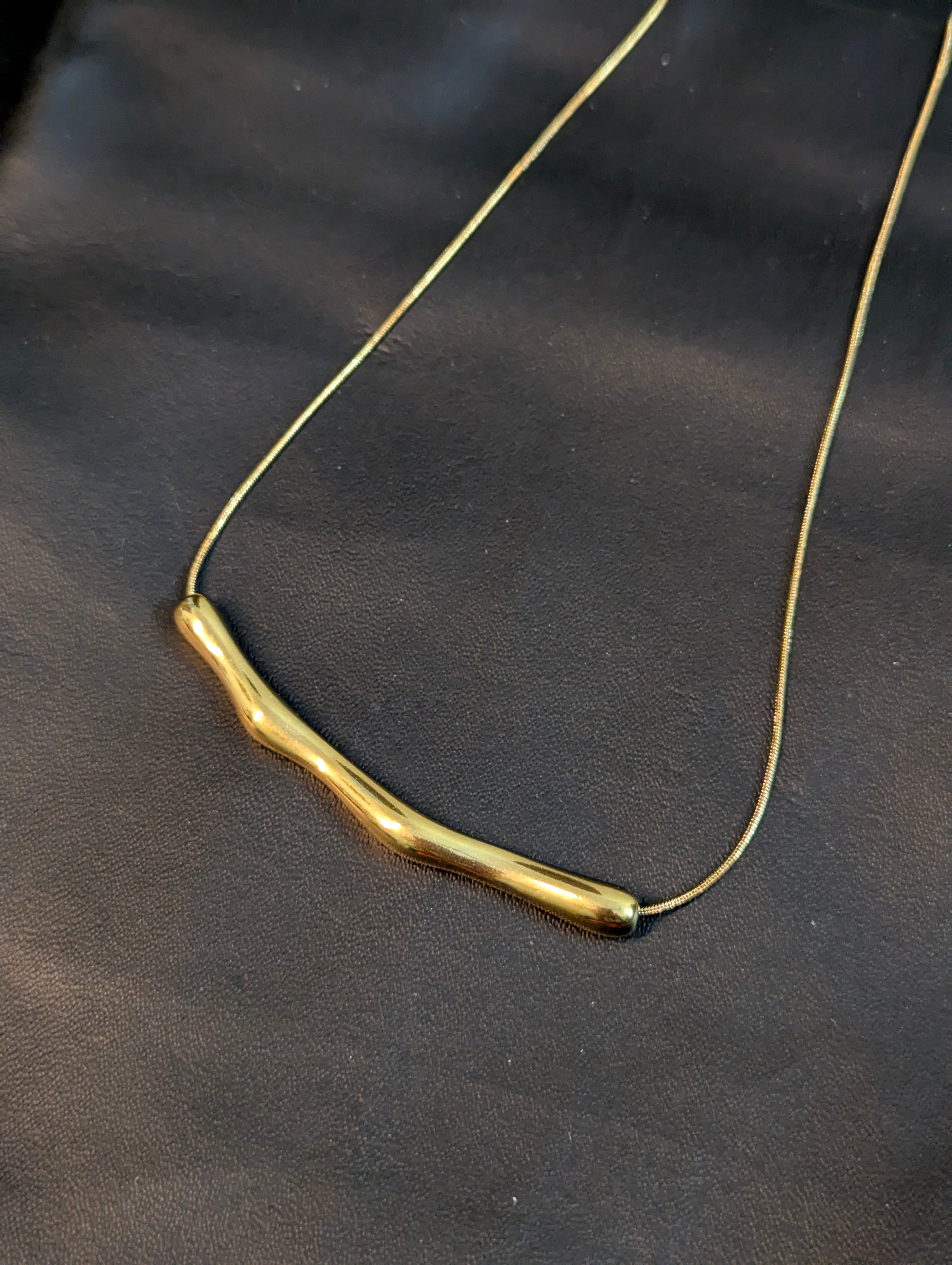 A statement arc necklace or bamboo-textured slice necklace